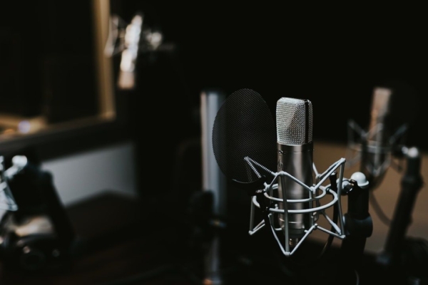 Studiomikrofon med popfilter i en mörk ljudinspelningsstudio